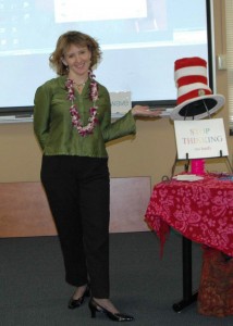 Veronica Adams pointing to a Dr. Seuss hat and a sign that reads 